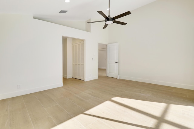 spare room with ceiling fan, light wood-type flooring, and high vaulted ceiling