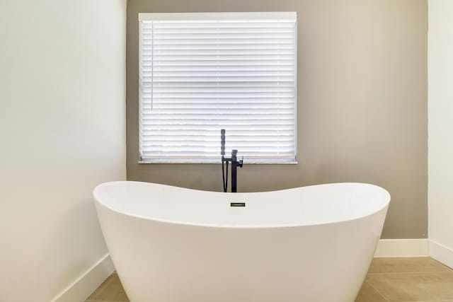 bathroom with a bathing tub and tile patterned flooring