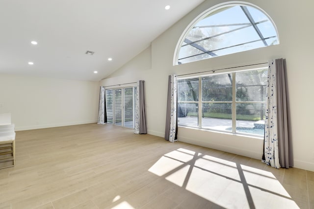 unfurnished living room with high vaulted ceiling and light hardwood / wood-style floors