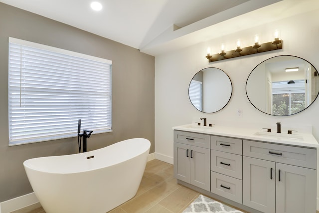 bathroom with hardwood / wood-style floors, lofted ceiling, vanity, and a bathing tub