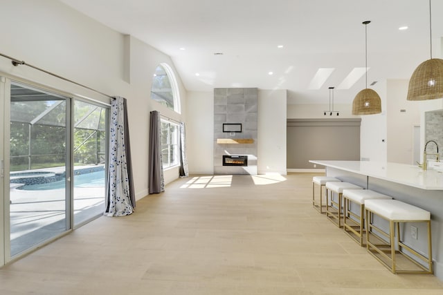 interior space with light wood-type flooring, high vaulted ceiling, and sink