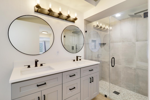 bathroom with a shower with shower door, vanity, and tile patterned floors