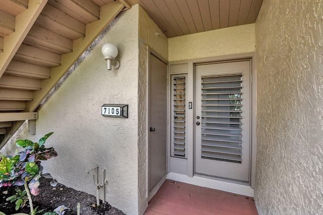 entrance to property featuring stucco siding