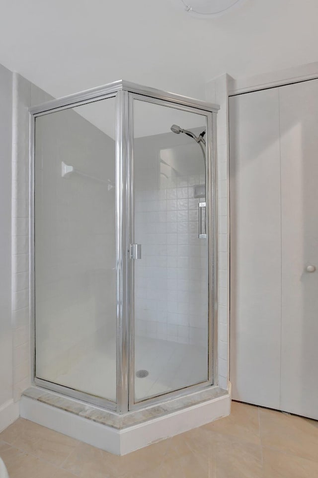 bathroom with tile patterned floors and walk in shower