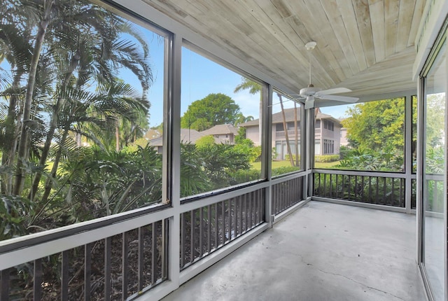 unfurnished sunroom with a wealth of natural light, wooden ceiling, and ceiling fan