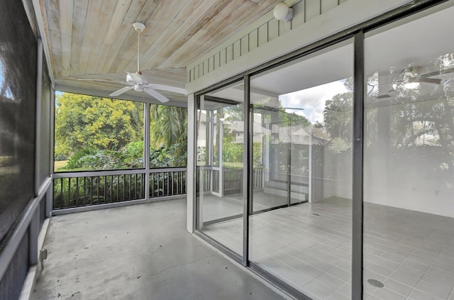 unfurnished sunroom featuring wood ceiling and ceiling fan