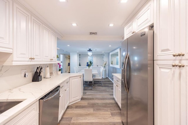 kitchen featuring white cabinetry, light hardwood / wood-style flooring, light stone counters, and appliances with stainless steel finishes