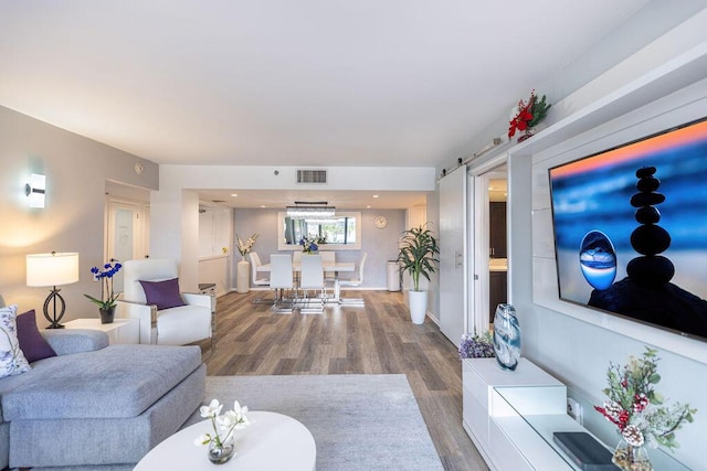 living room featuring a barn door and hardwood / wood-style floors