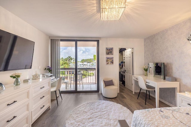 bedroom featuring access to exterior, a wall of windows, dark wood-type flooring, and an inviting chandelier