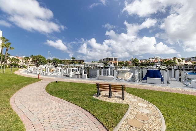 view of community with a water view, a yard, and a dock