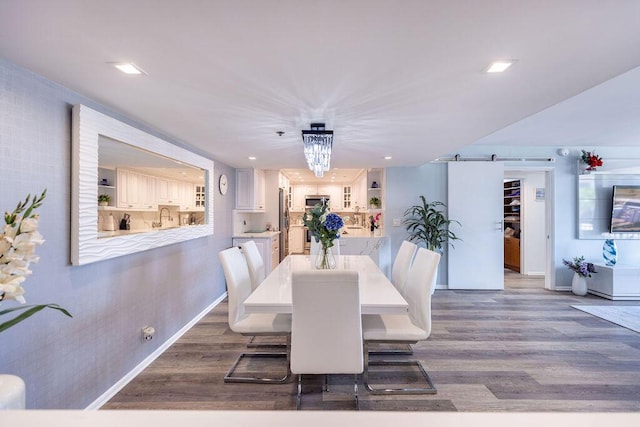 dining space with dark wood-type flooring and an inviting chandelier