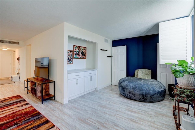 sitting room with light hardwood / wood-style flooring and a textured ceiling