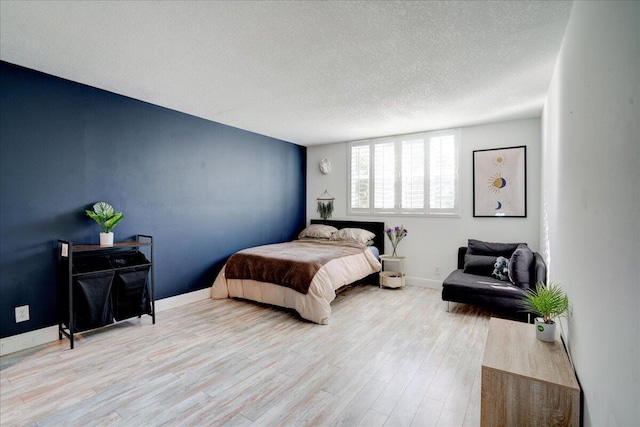 bedroom featuring light wood-type flooring and a textured ceiling