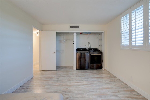 bar featuring plenty of natural light, light wood-type flooring, and separate washer and dryer