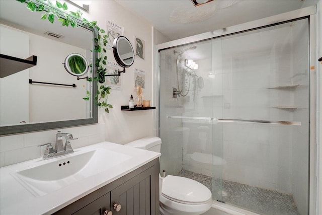 bathroom with vanity, toilet, walk in shower, and tasteful backsplash