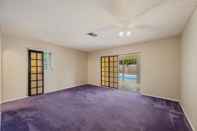 unfurnished room featuring a textured ceiling, carpet floors, and ceiling fan