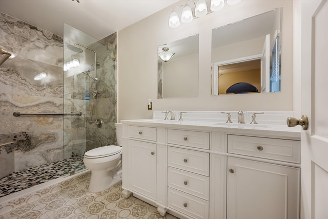 bathroom featuring vanity, tile patterned flooring, toilet, and a tile shower