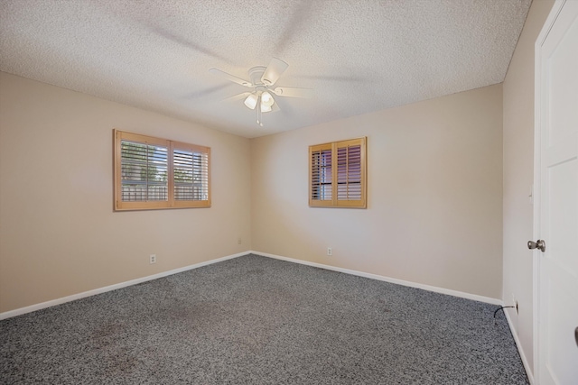 empty room featuring ceiling fan, dark carpet, and a textured ceiling