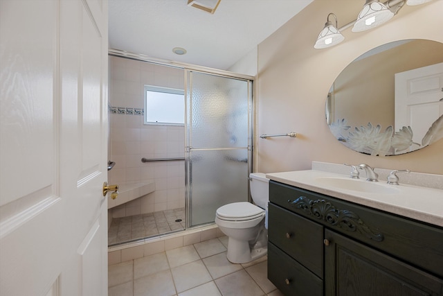 bathroom featuring tile patterned flooring, vanity, a shower with shower door, and toilet