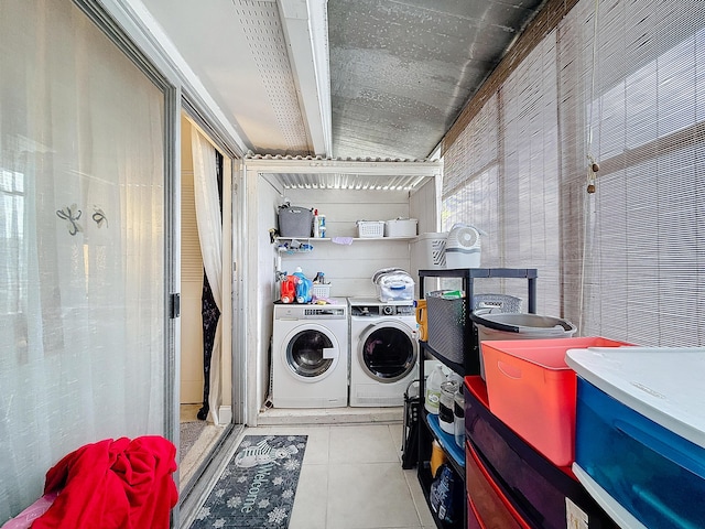 laundry area with independent washer and dryer and light tile patterned flooring