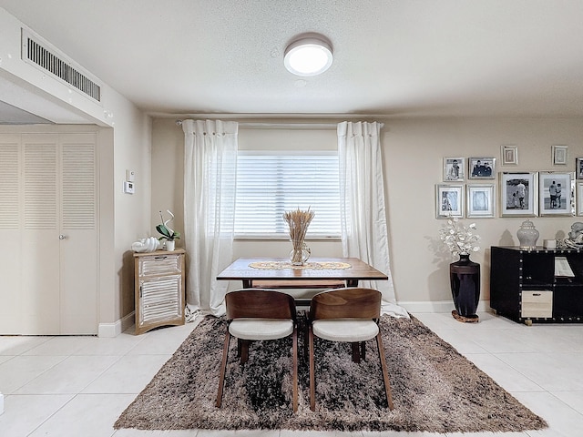 tiled dining area with a textured ceiling