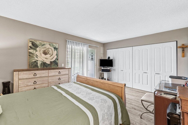 bedroom with a textured ceiling and light wood-type flooring