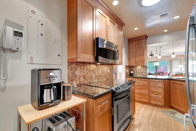 kitchen featuring stainless steel appliances, decorative light fixtures, wood counters, light hardwood / wood-style flooring, and decorative backsplash