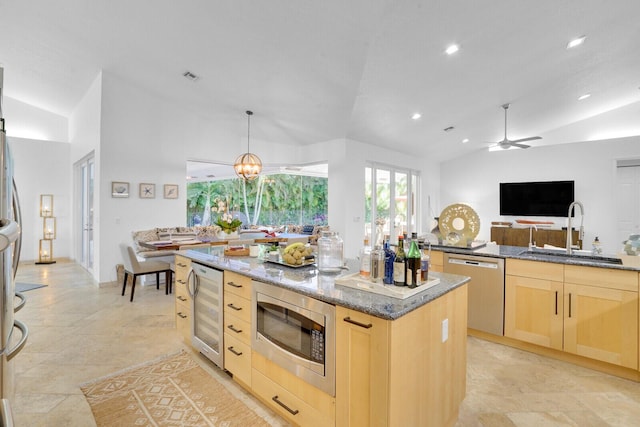 kitchen featuring appliances with stainless steel finishes, beverage cooler, light brown cabinets, a kitchen island, and lofted ceiling