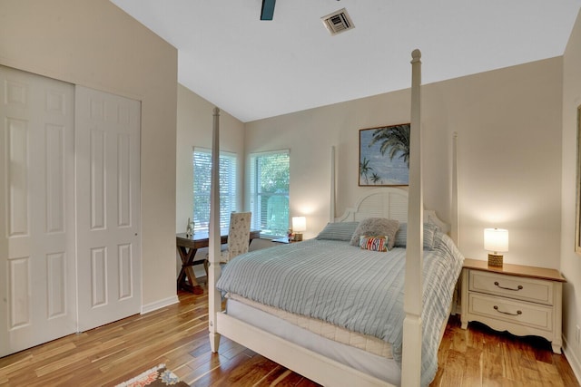 bedroom with ceiling fan, a closet, lofted ceiling, and light wood-type flooring