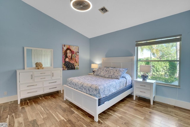 bedroom featuring lofted ceiling and light wood-type flooring