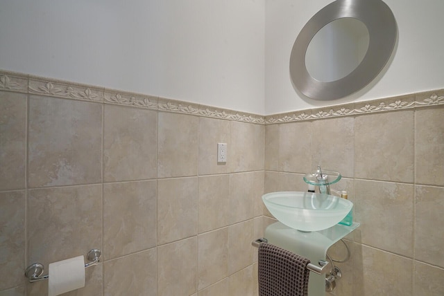 bathroom with sink and tile walls