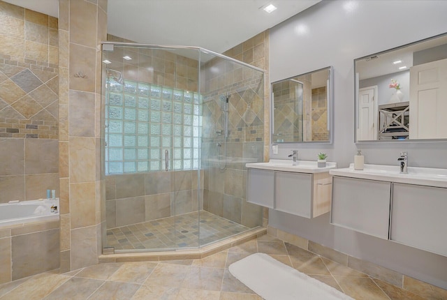 bathroom featuring shower with separate bathtub, vanity, and tile patterned floors