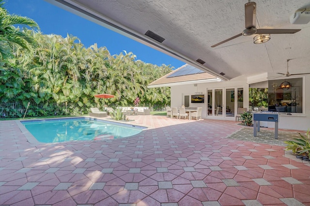 view of swimming pool featuring french doors, a patio, and ceiling fan