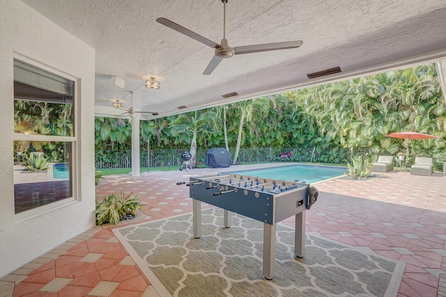 view of patio with a fenced in pool and ceiling fan