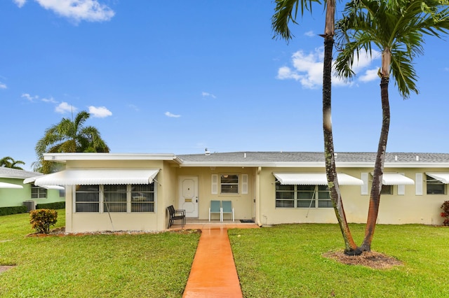 view of front facade with a front yard and stucco siding