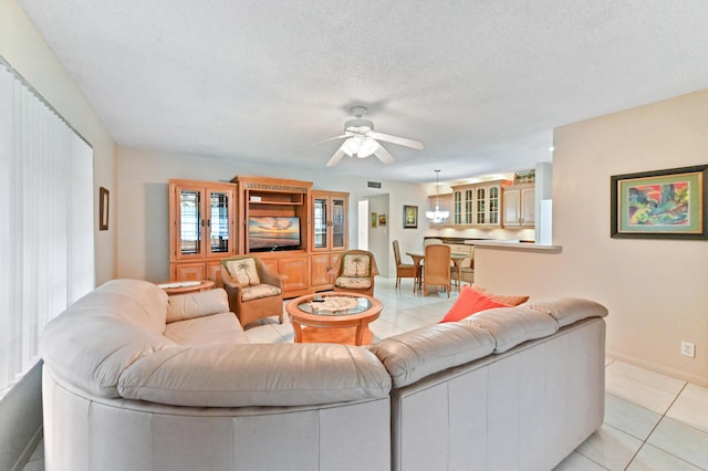 tiled living room with ceiling fan and a textured ceiling