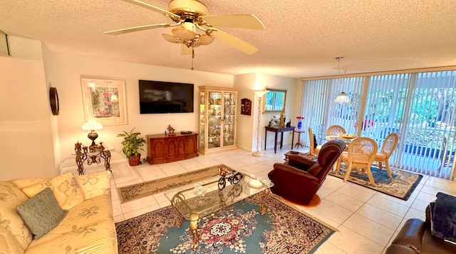 living room with ceiling fan, tile patterned flooring, expansive windows, and a textured ceiling