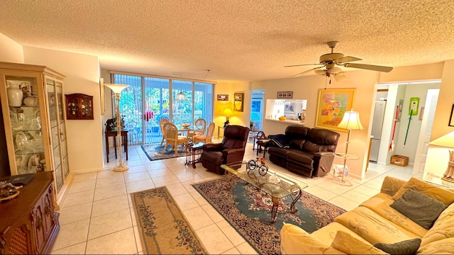 tiled living room with ceiling fan, floor to ceiling windows, and a textured ceiling