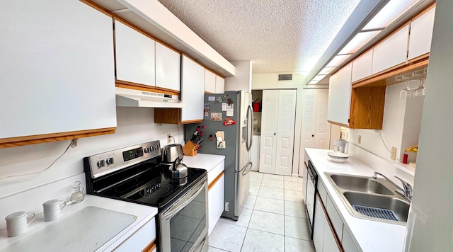 kitchen with white cabinets, sink, light tile patterned floors, a textured ceiling, and stainless steel appliances