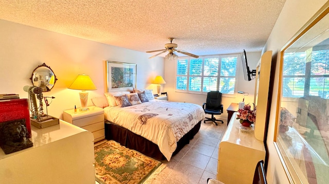 tiled bedroom with ceiling fan and a textured ceiling