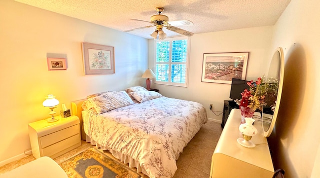 bedroom featuring ceiling fan, light tile patterned flooring, and a textured ceiling