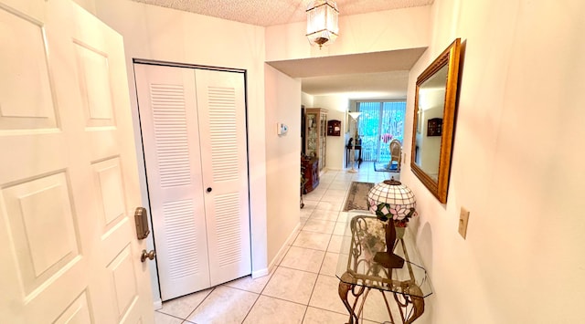 hallway featuring light tile patterned flooring and a textured ceiling