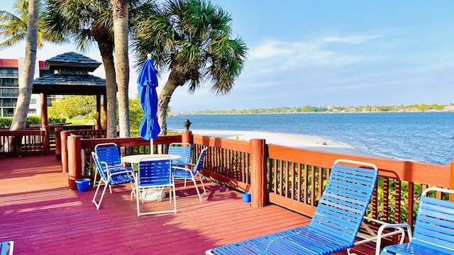 wooden terrace with a view of the beach and a water view