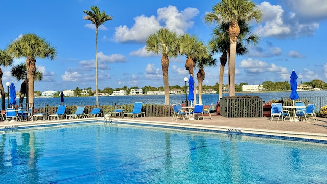 view of swimming pool with a patio area and a water view