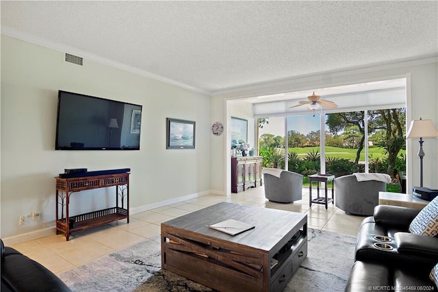 tiled living room with ceiling fan, ornamental molding, and a textured ceiling