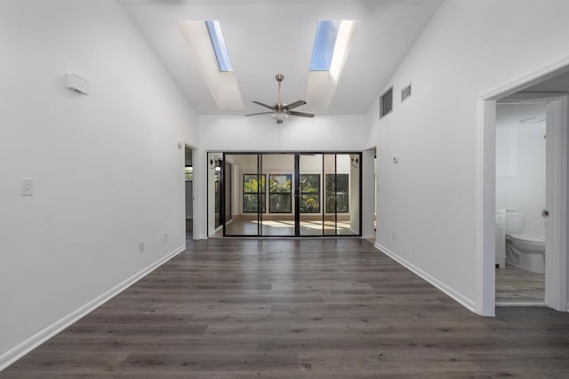 empty room with ceiling fan, dark hardwood / wood-style flooring, a skylight, and high vaulted ceiling