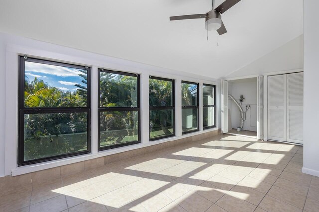 unfurnished sunroom with ceiling fan and vaulted ceiling