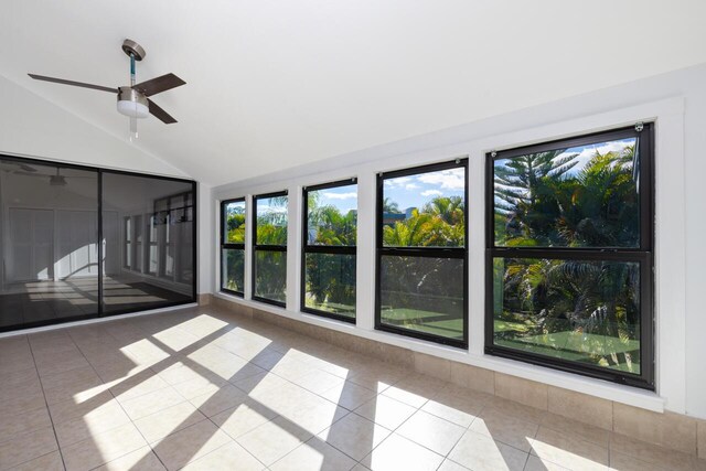 spare room featuring dark wood-type flooring, ceiling fan, and lofted ceiling with skylight