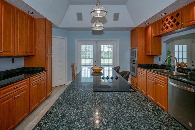 kitchen featuring decorative light fixtures, sink, dark stone counters, stainless steel appliances, and french doors