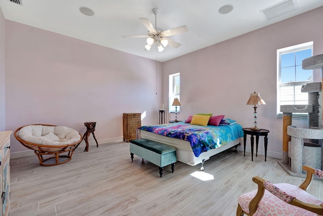 bedroom featuring multiple windows, ceiling fan, and light wood-type flooring